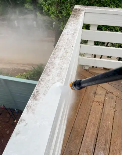 Hogedrukreiniging van wit geschilderde balustrades op het dek