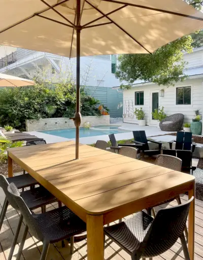 Table à manger en métal avec parasol dans la zone de la piscine