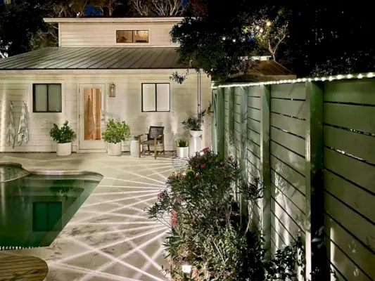 Luces de hadas LED solares a lo largo de la parte superior de la cerca cerca de la piscina del patio trasero