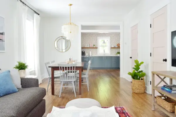 Sala d'estar de concepte obert amb portes rosades amb adorns blancs addicionals