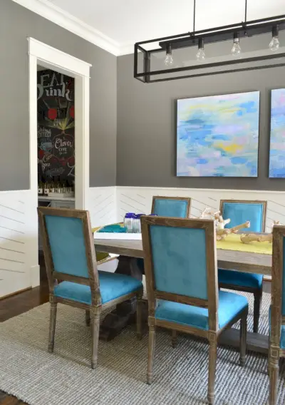 Comedor azul moderno con paredes de carbón Kendall y revestimiento de madera blanco