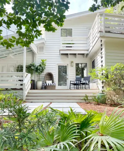 Exterior de una casa moderna blanca con revestimiento y paisajismo de Florida