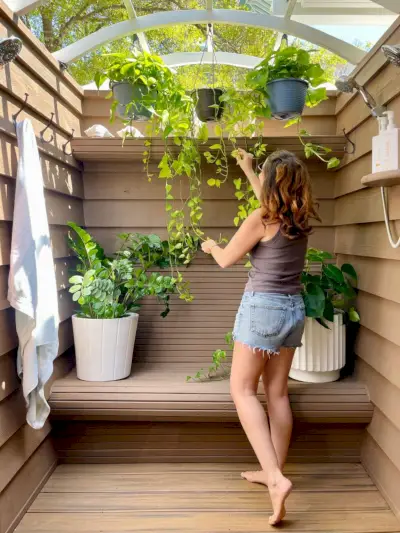 Plantes suspendues Sherry dans une douche extérieure avec une teinture solide Behr sur les murs