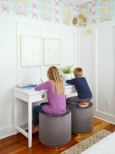 Enfants assis sur des tabourets comme bureau dans la chambre Beachy