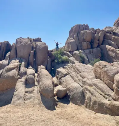 Menina no topo de rochas escaladas no Parque Nacional Joshua Tree