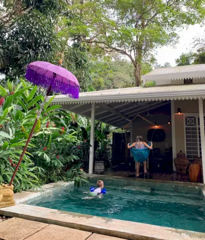 Nens jugant a l'Airbnb tropical de Costa Rica amb piscina i gronxador