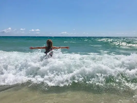 liten jente som leker i bølger under Spring Break i Lauderdale By The Sea Florida