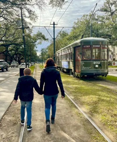 Mamá y niño caminando cerca del tranvía de Nueva Orleans