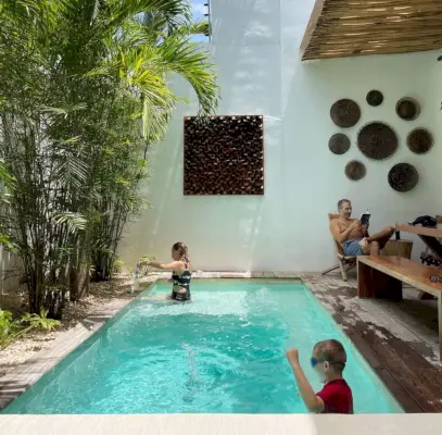 Dzieci bawiące się w Johna czytającego na basenie Airbnb w Tulum w Meksyku