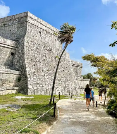 Enfants marchant devant le château des ruines de Tulum au Mexique